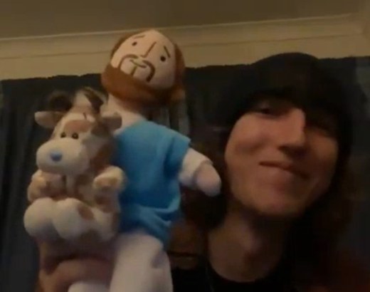 A church member on a video call holding a plush Jesus and a plush cow